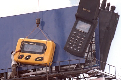 A worker 23 June struggles to install an oversized copy of a pager on a central Phnom Penh billboard...