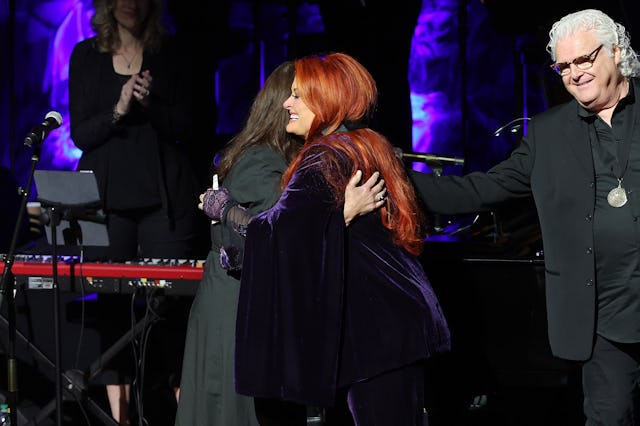 Ashley Judd accepts induction on behalf of Naomi Judd with inductee Wynonna Judd and Ricky Skaggs on...