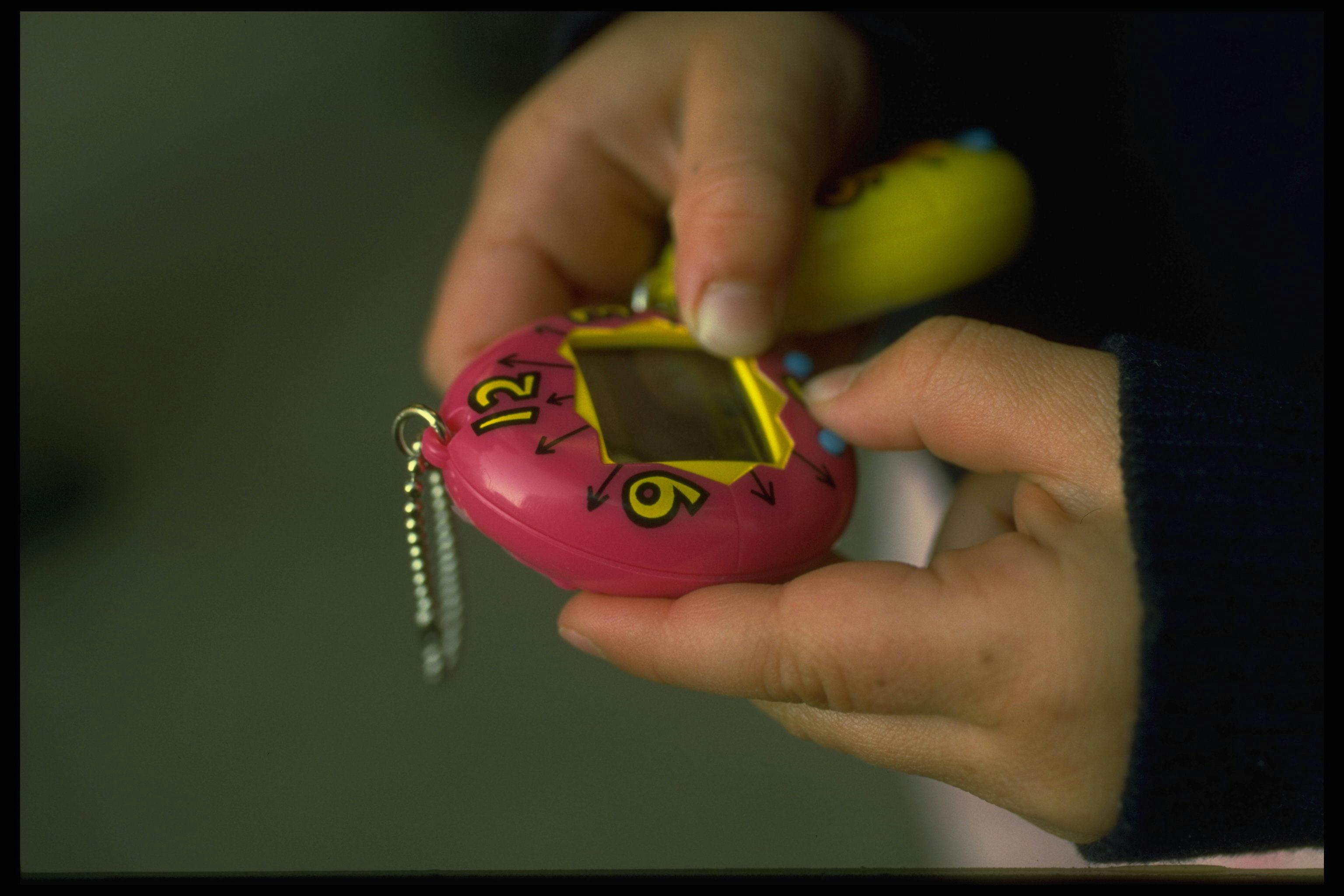 A girl playing with an original tamagotchi in the '90s. The toys came out in the u.s. in May 1997.