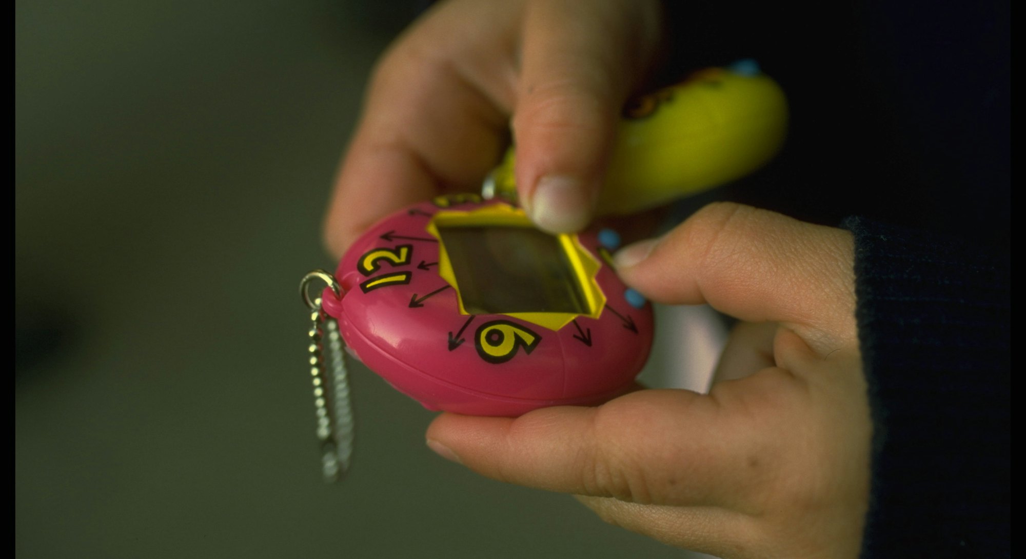 A girl playing with an original tamagotchi in the '90s. The toys came out in the u.s. in May 1997.