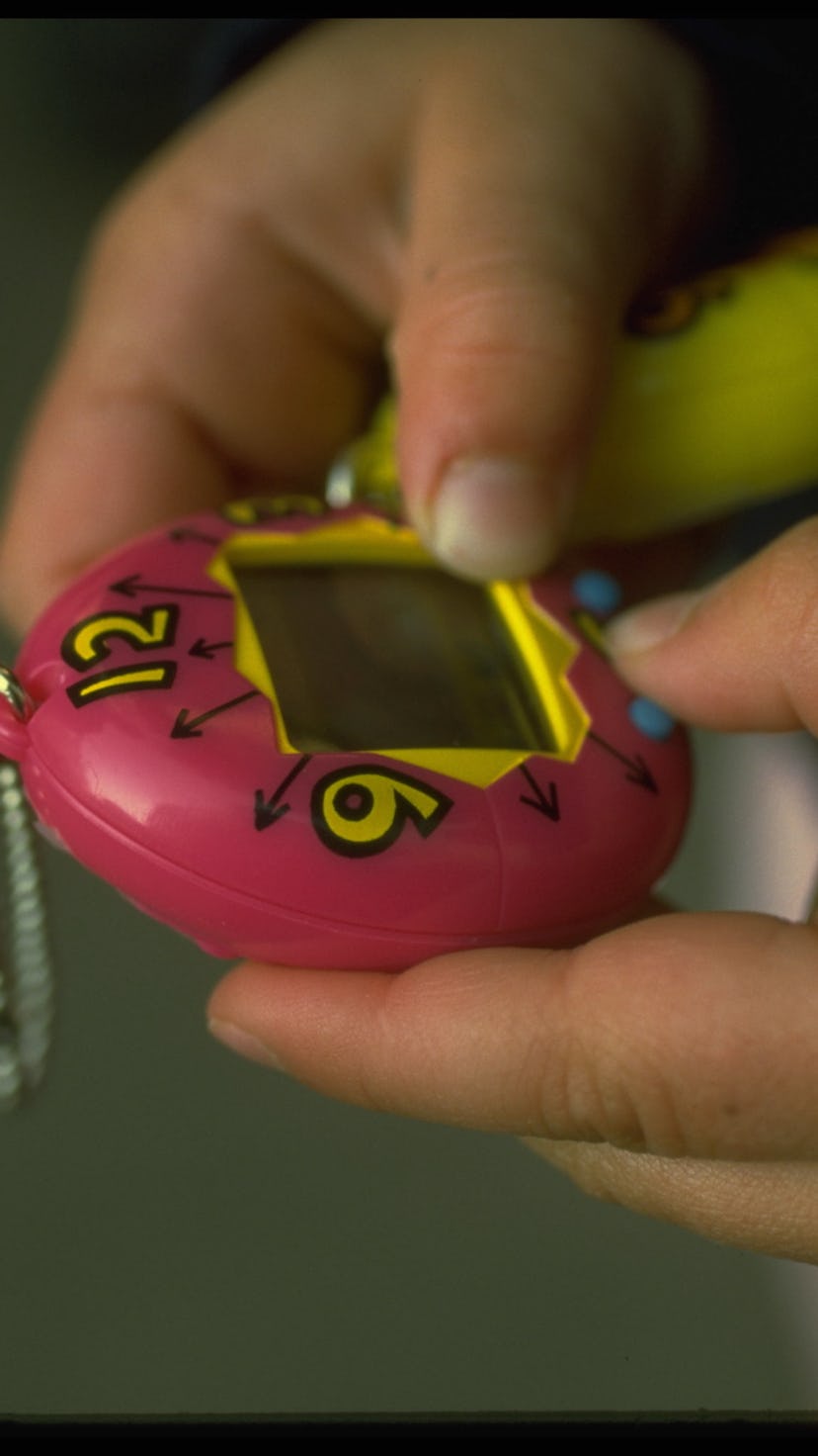A girl playing with an original tamagotchi in the '90s. The toys came out in the u.s. in May 1997.
