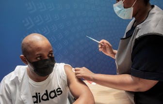 A man receives a dose of the Pfizer/BioNTech vaccine against COVID-19 at Discovery vaccination site ...