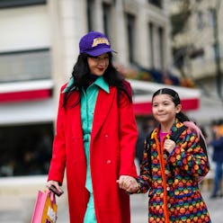 PARIS, FRANCE - MARCH 03: A guest (L) wears  purple with embroidered yellow pattern cap, a green min...