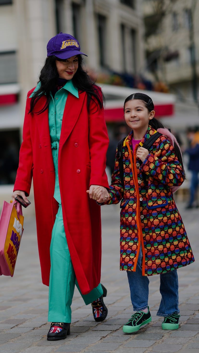 PARIS, FRANCE - MARCH 03: A guest (L) wears purple with embroidered yellow pattern cap, a green min...