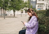 Young woman checking her smart phone outdoors in an urban setting. How to see who viewed your TikTok...