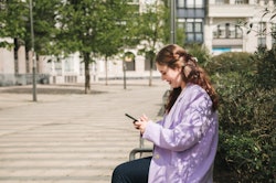 Young woman checking her smart phone outdoors in an urban setting. How to see who viewed your TikTok...