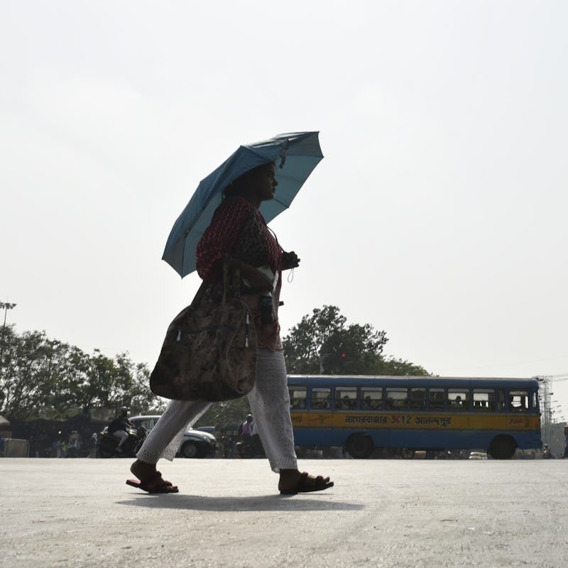 A woman carry an umbrella amid heatwave in Kolkata, India, 29 April, 2022. (Photo by Indranil Adity...