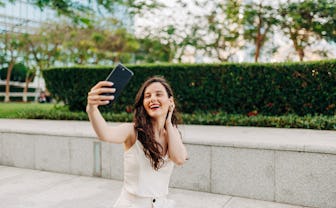 Beautiful woman taking a selfie by her smart phone