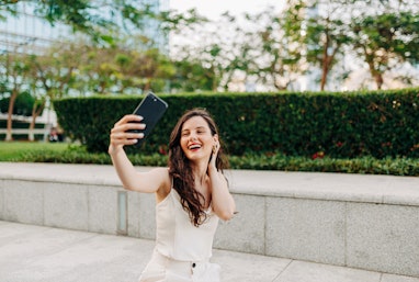 Beautiful woman taking a selfie by her smart phone