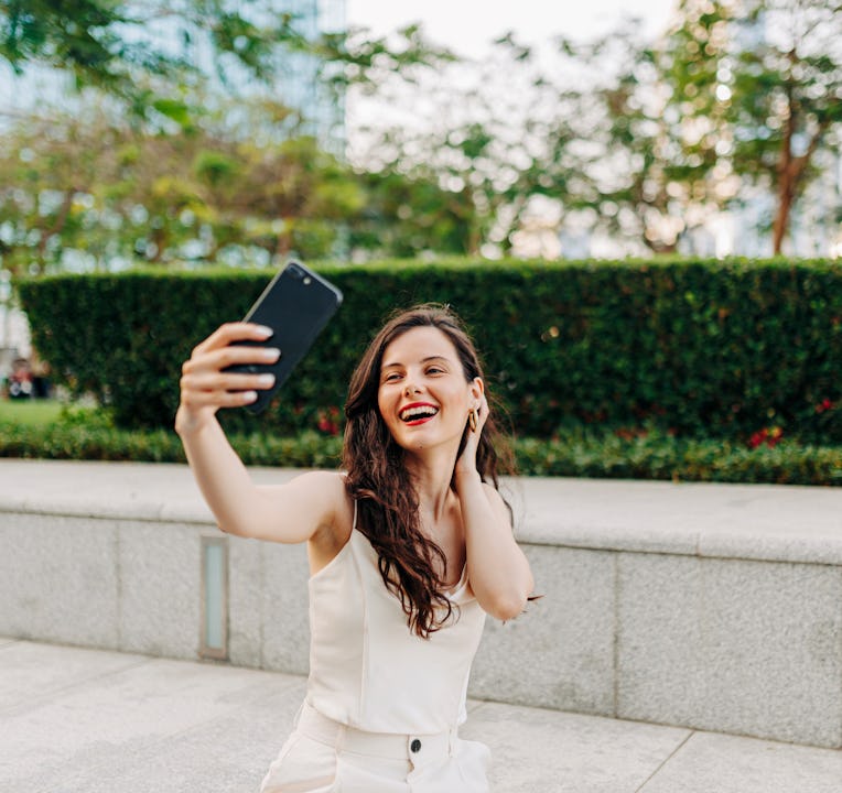 Beautiful woman taking a selfie by her smart phone