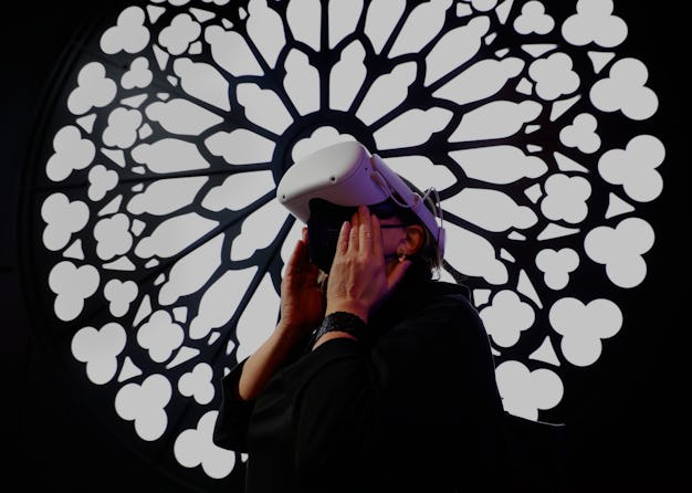 A congress attendant visiting the cathedral Notre Dame de Paris with the Meta Oculus Quest 2 headset...