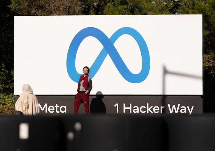 MENLO PARK, CALIFORNIA - OCTOBER 28: People take pictures in front of a sign showing logo of Meta ou...