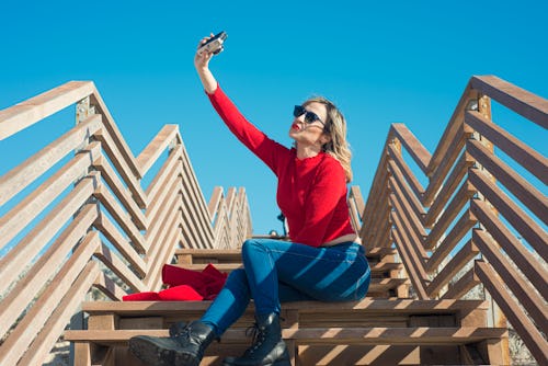 Young woman taking selfie. Here’s your may 24 zodiac sign daily horoscope