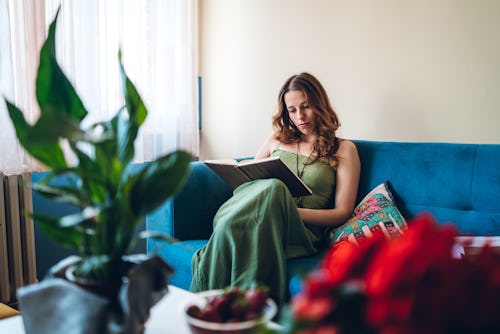 Young woman studying at home on sofa. Here's your May 25 zodiac sign daily horoscope.
