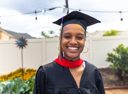 A woman smiles for her graduation, which she'll post about with high school graduation Instagram cap...