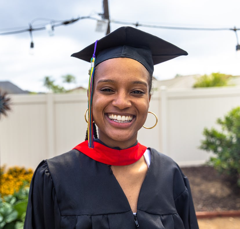 A woman smiles for her graduation, which she'll post about with high school graduation Instagram cap...