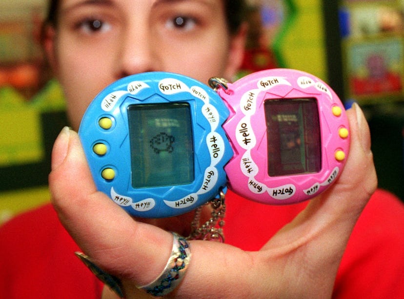 Person holding two Tamagotchis.
