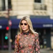 PARIS, FRANCE - OCTOBER 31: Kate Tik wears black sunglasses, a black with red / purple / green flowe...