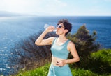 Sporty young woman drinking water. The may 2022 new moon in gemini will affect these zodiac signs th...