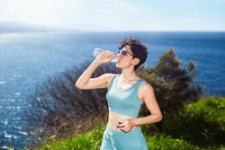 Sporty young woman drinking water. The may 2022 new moon in gemini will affect these zodiac signs th...