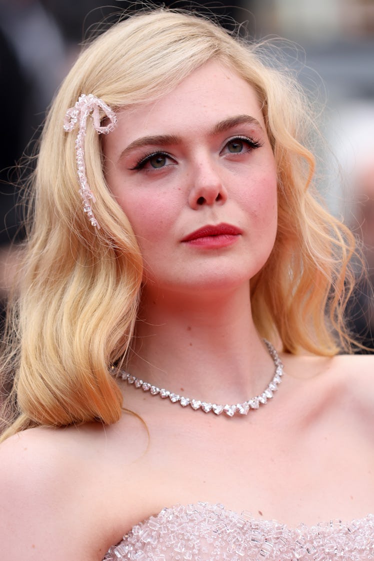 Elle Fanning at the screening of "Top Gun: Maverick" in a strapless gown and a diamond necklace alon...