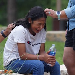 TOPSHOT - A girl cries, comforted by two adults, outside the Willie de Leon Civic Center where grief...