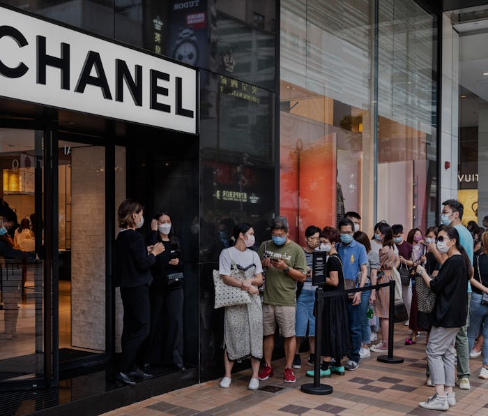 HONG KONG, CHINA - 2021/08/07: Shoppers queue at the entrance of the French multinational Chanel clo...