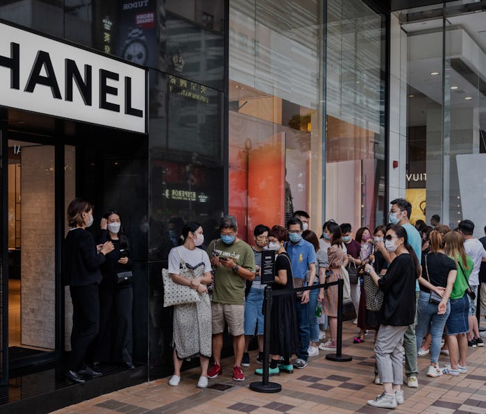HONG KONG, CHINA - 2021/08/07: Shoppers queue at the entrance of the French multinational Chanel clo...