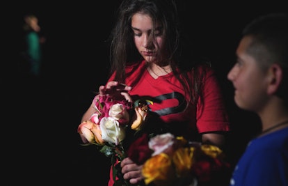 A young girl holds flowers outside the Willie de Leon Civic Center where people gather to mourn in U...
