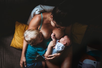 Mother tandem breastfeeds toddler and newborn in an article about if breastfeeding can cause contrac...