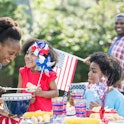 An African American mother with two mixed race children celebrating an American patriotic holiday, p...