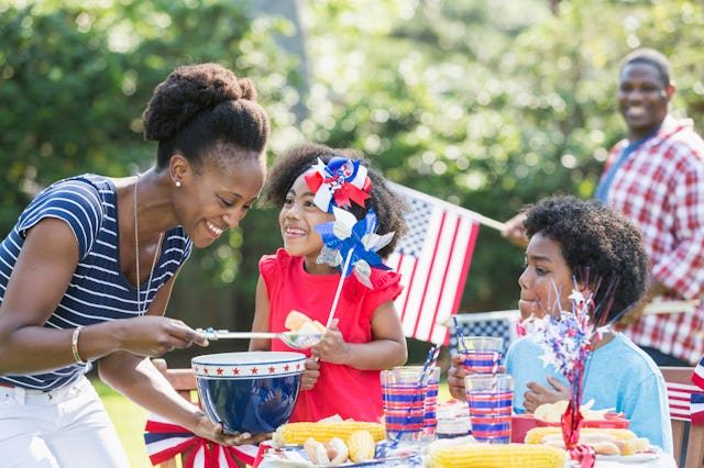 An African American mother with two mixed race children celebrating an American patriotic holiday, p...