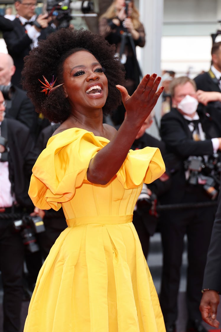 Viola Davis at the screening of Top Gun: Maverick in a yellow gown and a floral decoration in her ha...