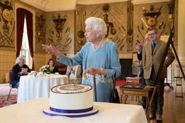 TOPSHOT - Britain's Queen Elizabeth II cuts a cake to celebrate the start of the Platinum Jubilee du...