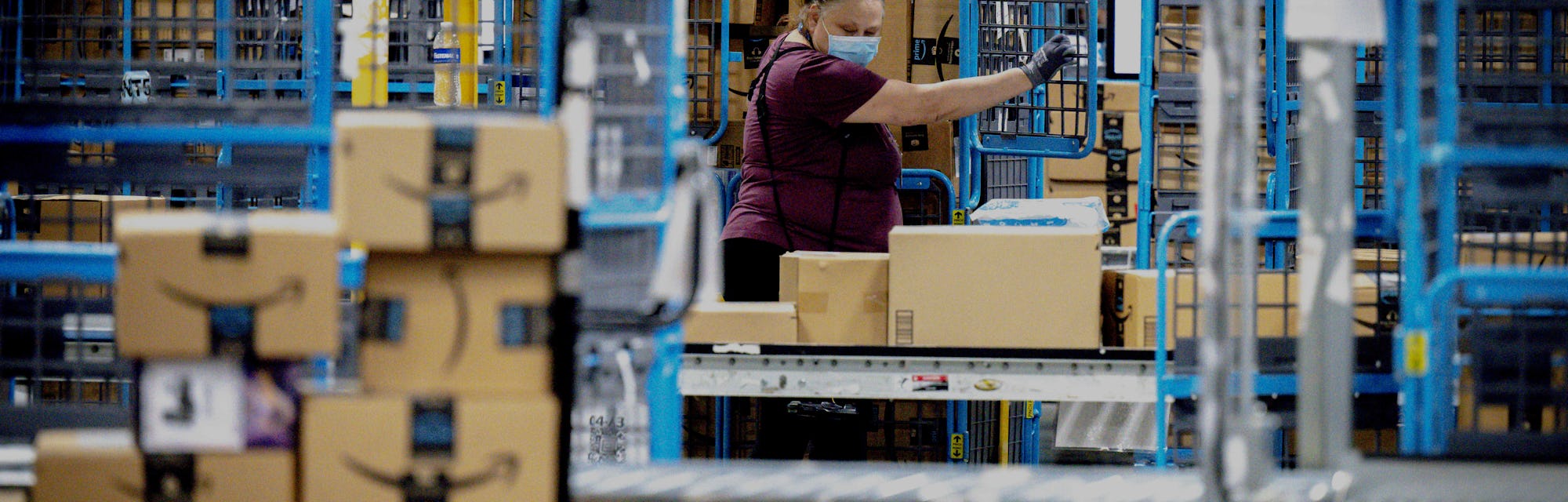 EASTVALE, CA - AUGUST 31: A worker sorts out packages in the outbound dock at Amazon fulfillment cen...