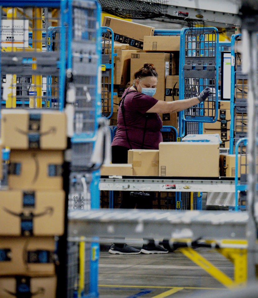 EASTVALE, CA - AUGUST 31: A worker sorts out packages in the outbound dock at Amazon fulfillment cen...
