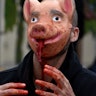 MARSEILLE, FRANCE - 2022/02/13: A protester is seen wearing a pig mask splattered with red paint to ...
