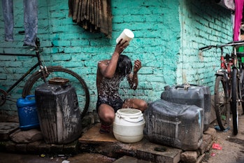 A boy bathes during a hot summer day in New Delhi on May 3, 2022. (Photo by Xavier GALIANA / AFP) (P...