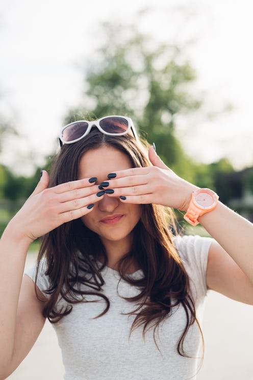 Beautiful girl hiding eyes with hands