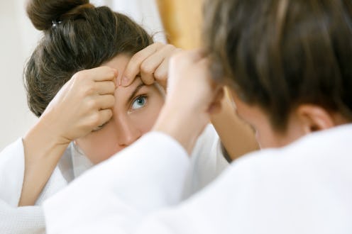 woman popping a pimple