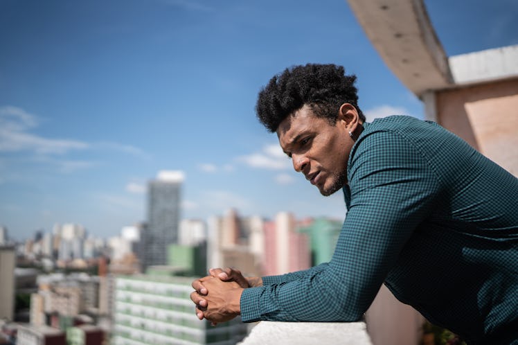 Contemplative mid adult man on apartment's balcony