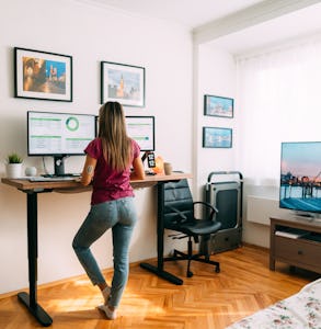 Rear view of woman working remotely from home at standing desk