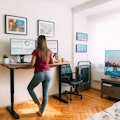 Rear view of woman working remotely from home at standing desk