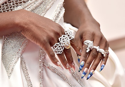 A close-up of Cynthia Erivo's hands while wearing large rings and showing off her blue and white nai...