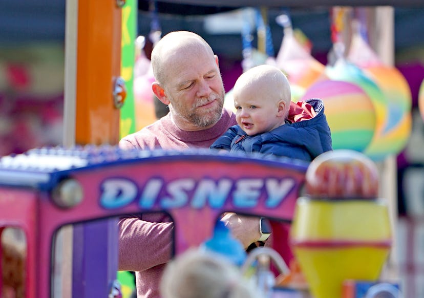Mike Tindall holds his son Lucas Tindall as they watch Lena Tindall (not seen) on a ride, in the fai…