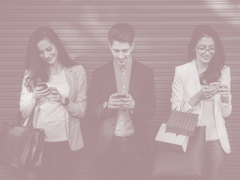 Group of friends using smartphones outside