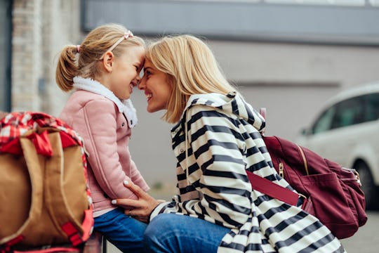 Lovely moments of beautiful mother and her preschool daughter in front of school