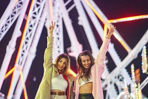 Female friends flash peace signs at a music festival. Festify, a spotify plug in, will turn your mus...