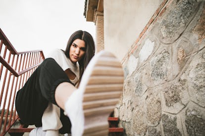 young woman kicks foot towards camera as she discusses the may 23, 2022 astrology for the week