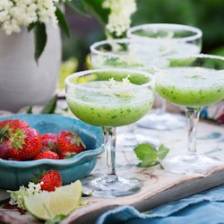 Glass of cucumber cocktail decorated with flowers